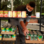 worker stacking cans of food