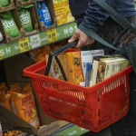 Person holding shopping basket at grocery store