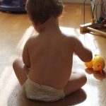Photo of baby on floor playing with a toy